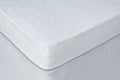 White waterproof bamboo terry cloth crib mattress cover on a crib mattress.