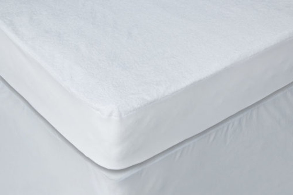 White waterproof bamboo terry cloth crib mattress cover on a crib mattress.