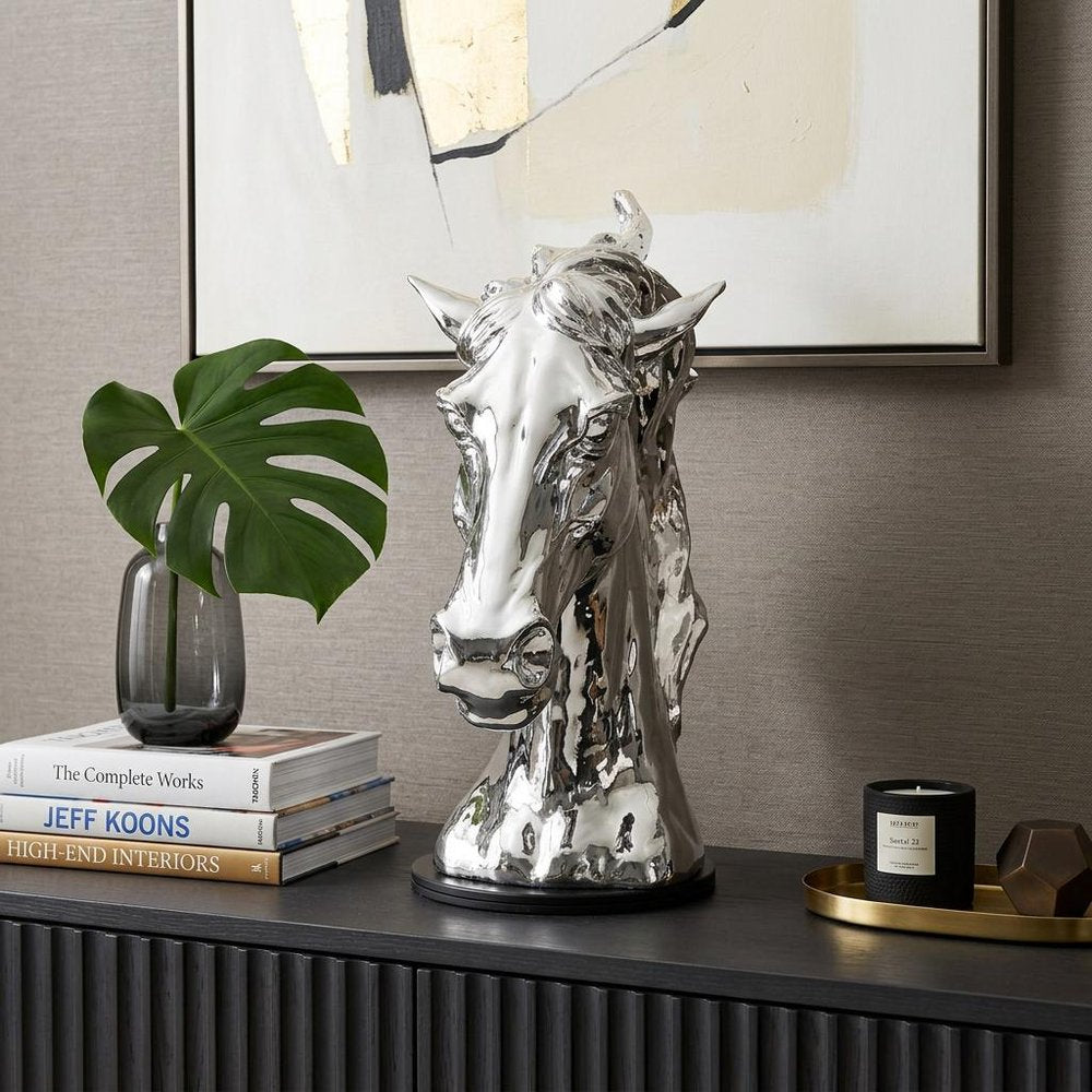 11" Silver Glass Figurine Tabletop Sculpture styled in a furnished interior with an off-white wall on a black floor.