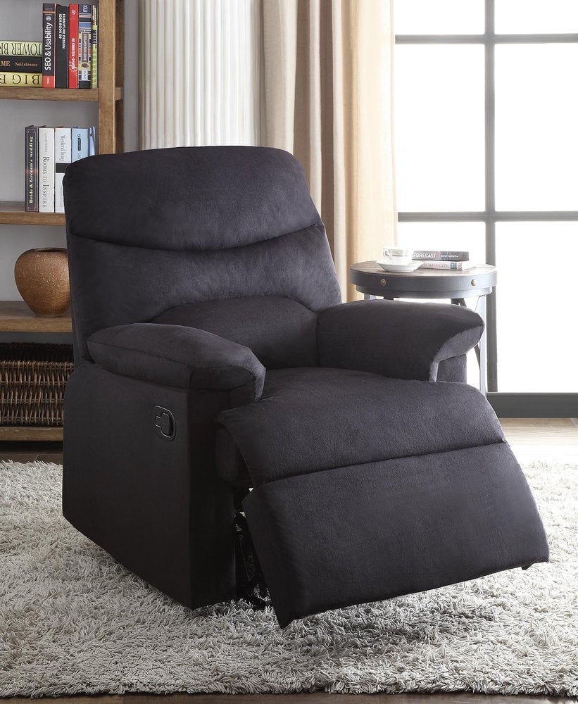 Black microfiber manual recliner in a living room with a bookshelf and window.