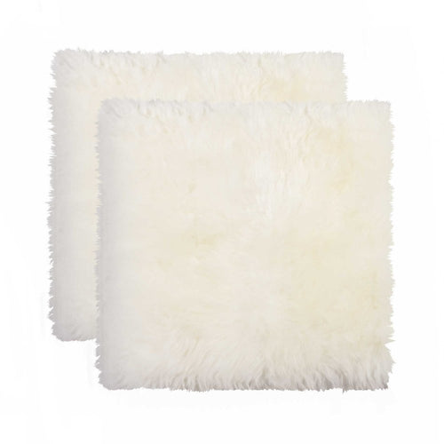 Two off-white synthetic pads with fluffy texture on a white background.