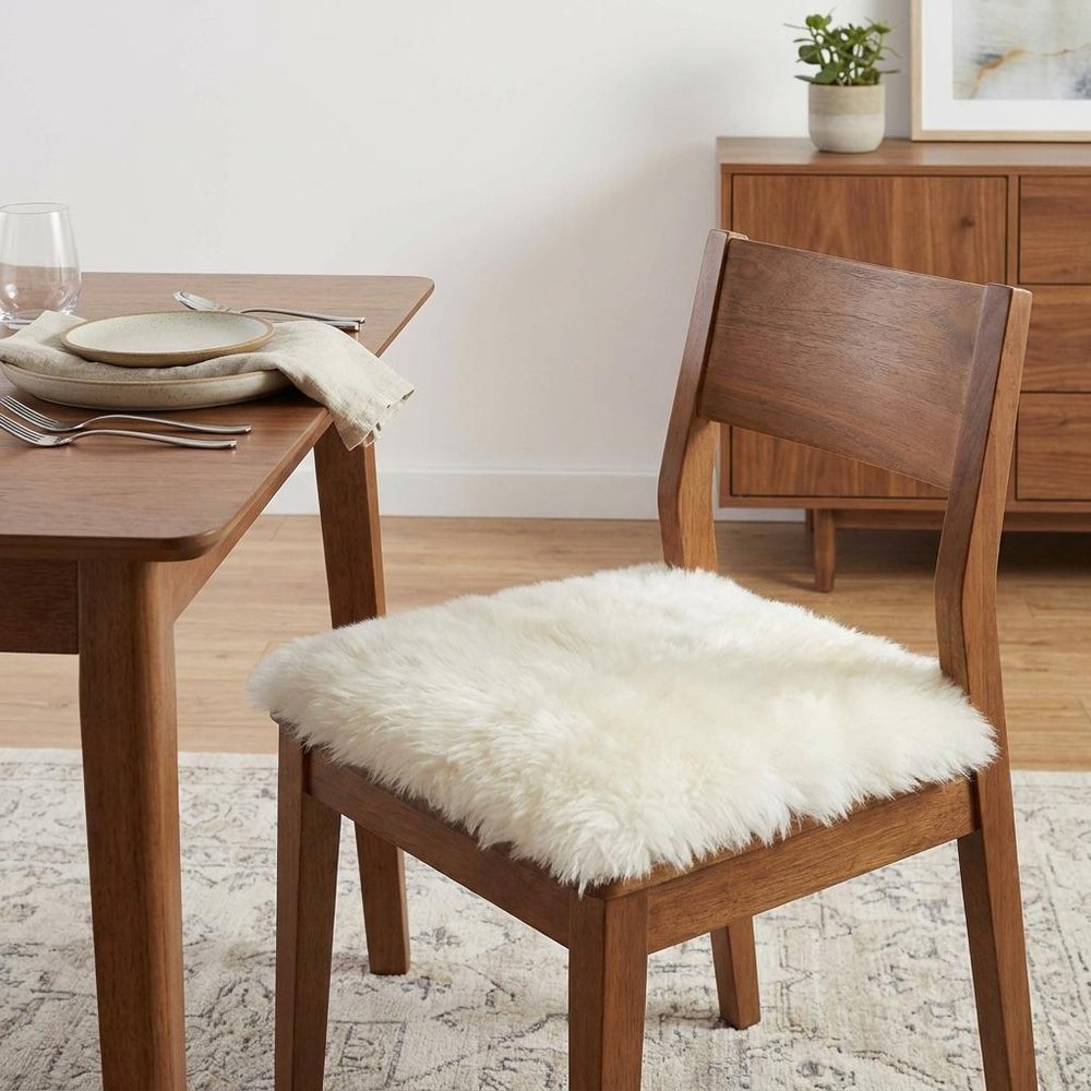 17" X 17" Off White Synthetic Solid Color Pad styled in a furnished interior with an off-white wall on a wood floor in off-white.