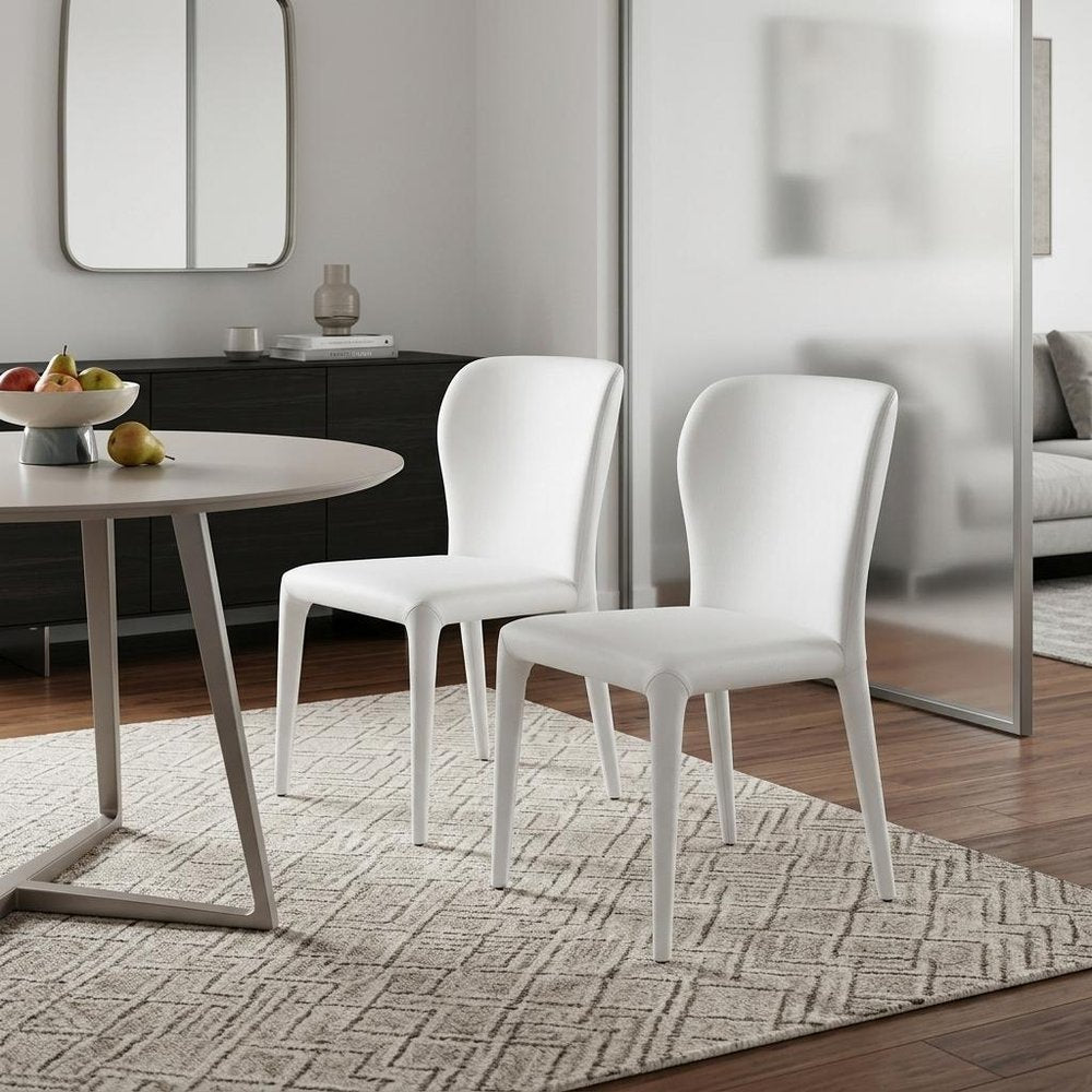 Set of Two White Upholstered Faux Leather Dining Side Chairs - 35" H x 20" W x 24" D in a home interior