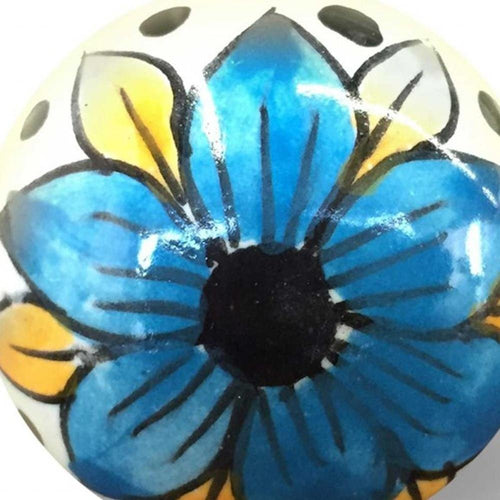 1.5" X 1.5" X 1.5" Blue Black And Yellow Knobs 8 Pack. Close-up of a glazed ceramic knob painted with a blue flower, yellow petals, and a black center on a white background.