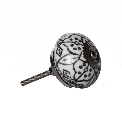 Round ceramic drawer knob with black and gray floral pattern and silver metal base and screw on a white background.