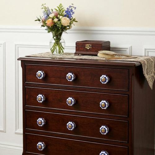 1.5" X 1.5" X 1.5" White Blue And Gold Knobs 12 Pack installed on a wood dresser in a furnished interior with an off-white wall.