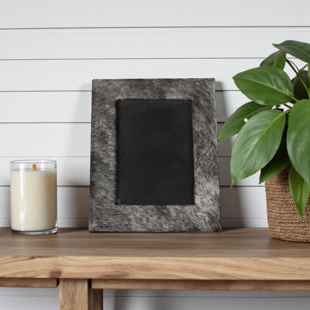 4" x 6" Black Cowhide Picture Frame with Mat shown outdoors on an outdoor setting with greenery.