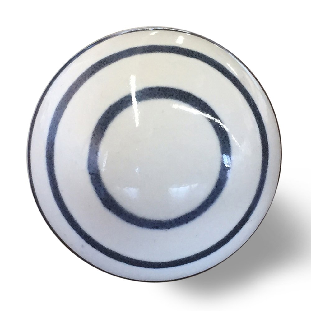 White ceramic drawer knob with concentric dark blue rings on a white background.
