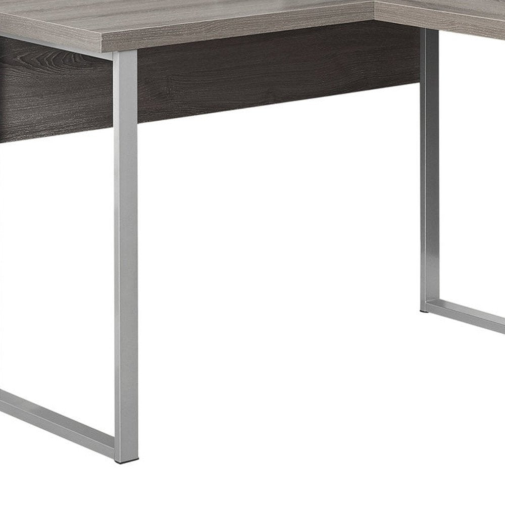 Close-up of a taupe and silver L-shaped computer desk with metal legs against a white background.