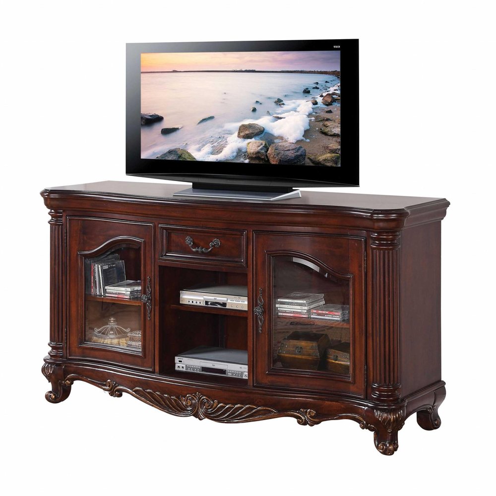 Brown cherry wood TV stand with glass doors, open shelves, and a drawer, featuring ornate carvings and decorative legs.