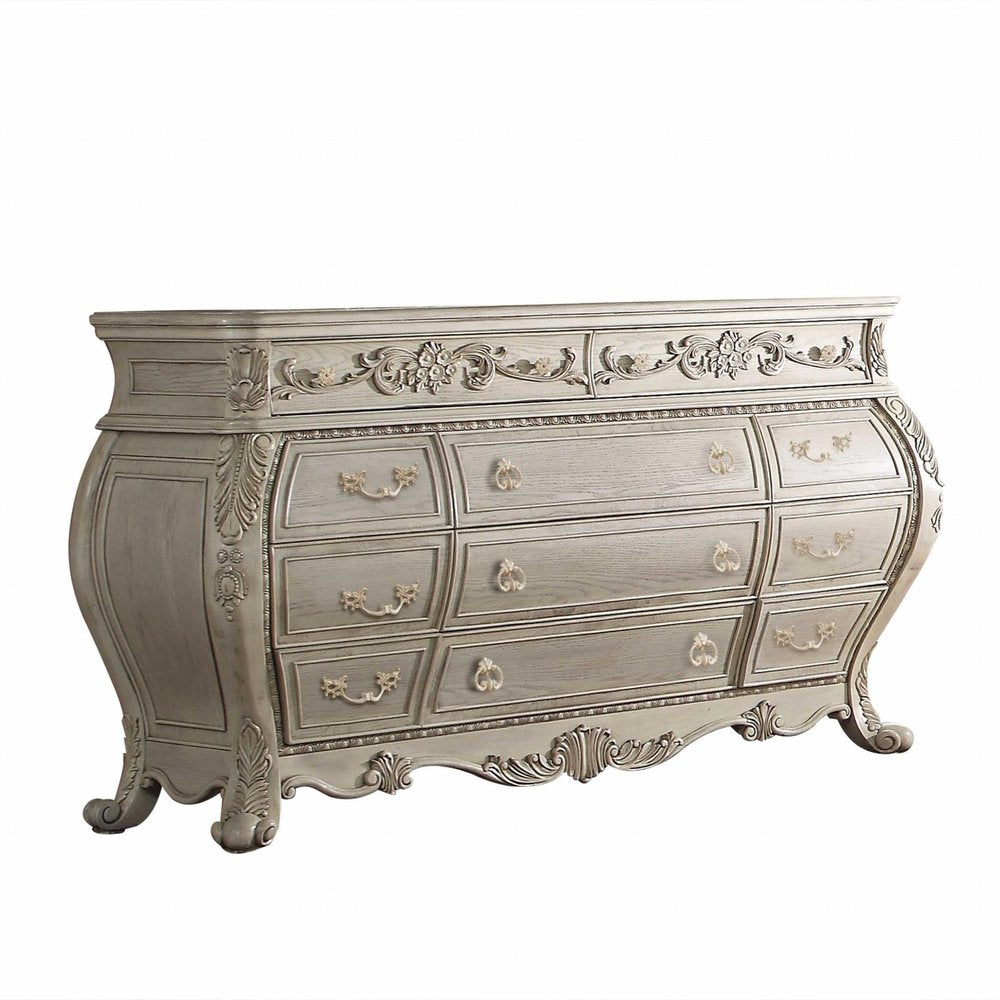 Off-white solid wood nine-drawer double dresser with ornate carvings and gold hardware on a white background.
