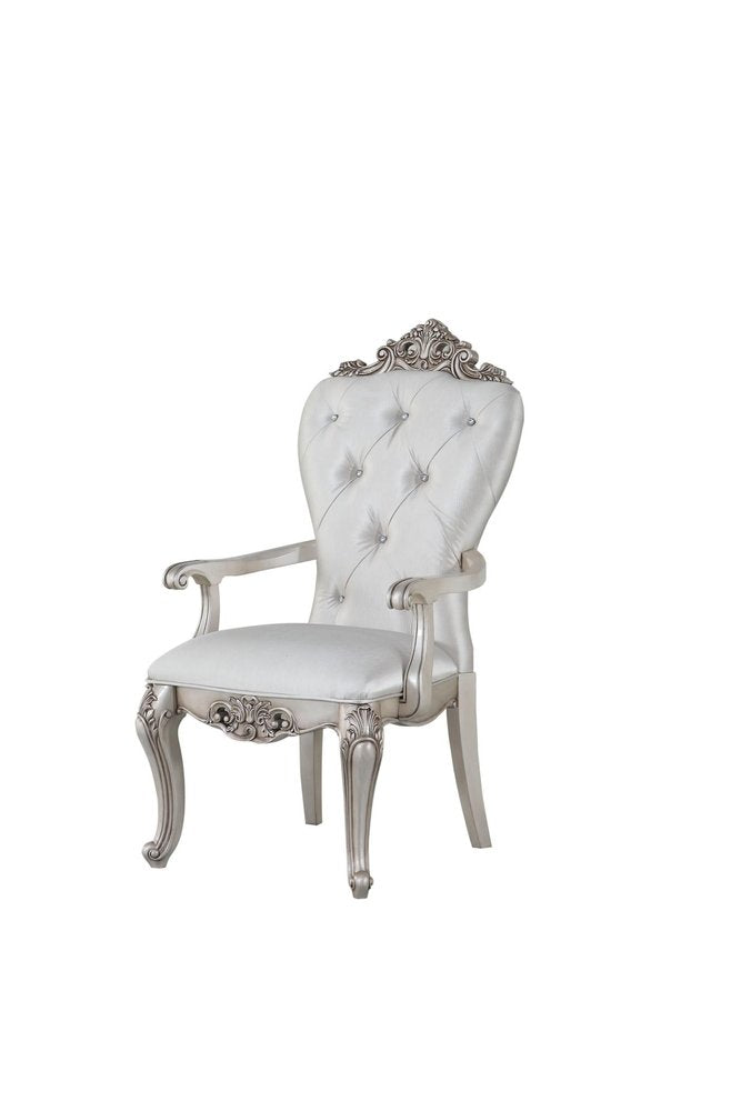 A silver tufted armchair with pearl fabric upholstery and ornate carved legs on a white background.