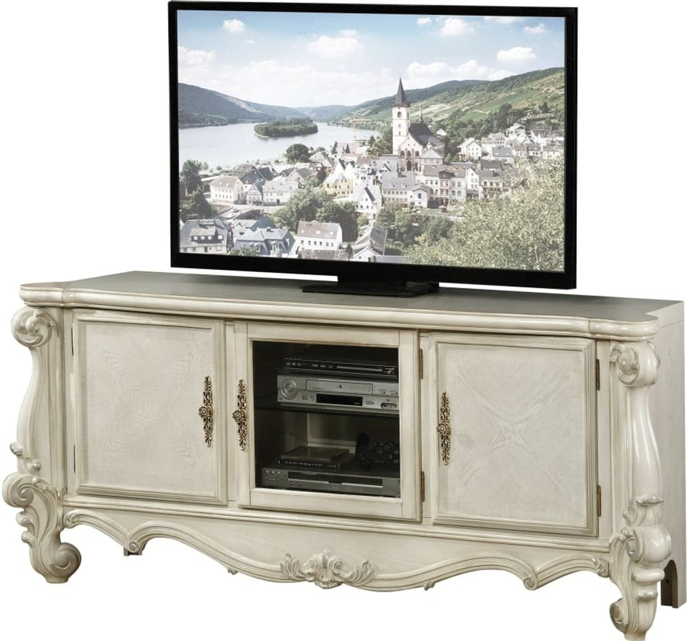 Off-white carved scrollwork entertainment center with glass and open storage, featuring a television displaying a European village scene.