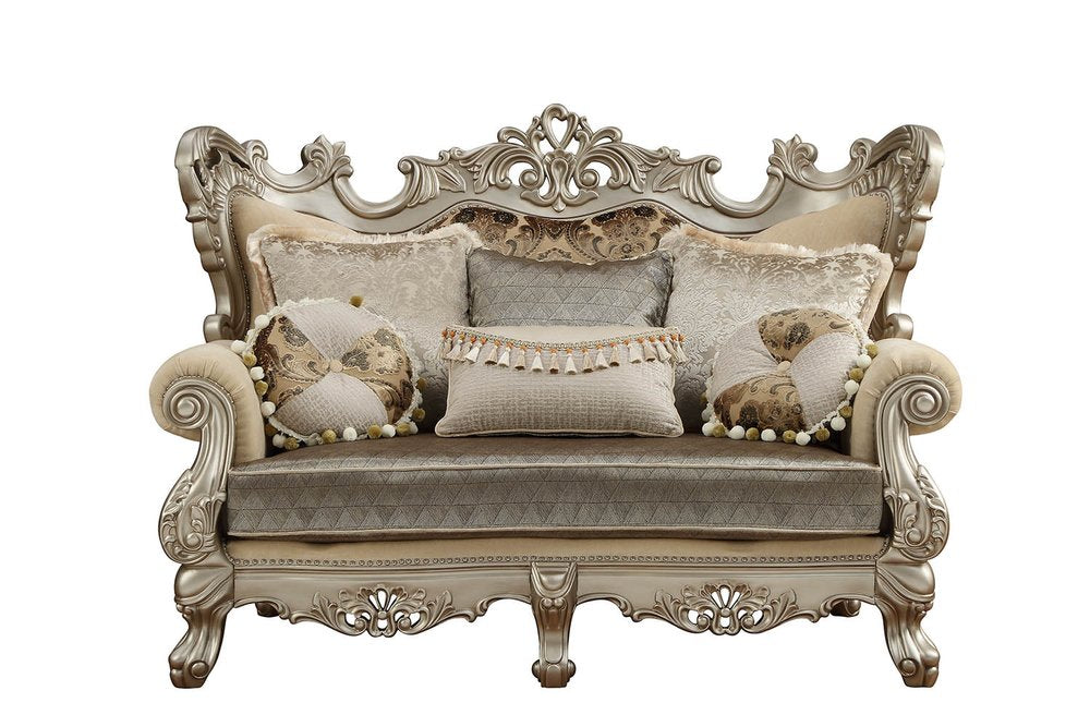 Cream and platinum damask loveseat with ornate carved details and decorative toss pillows on a white background.