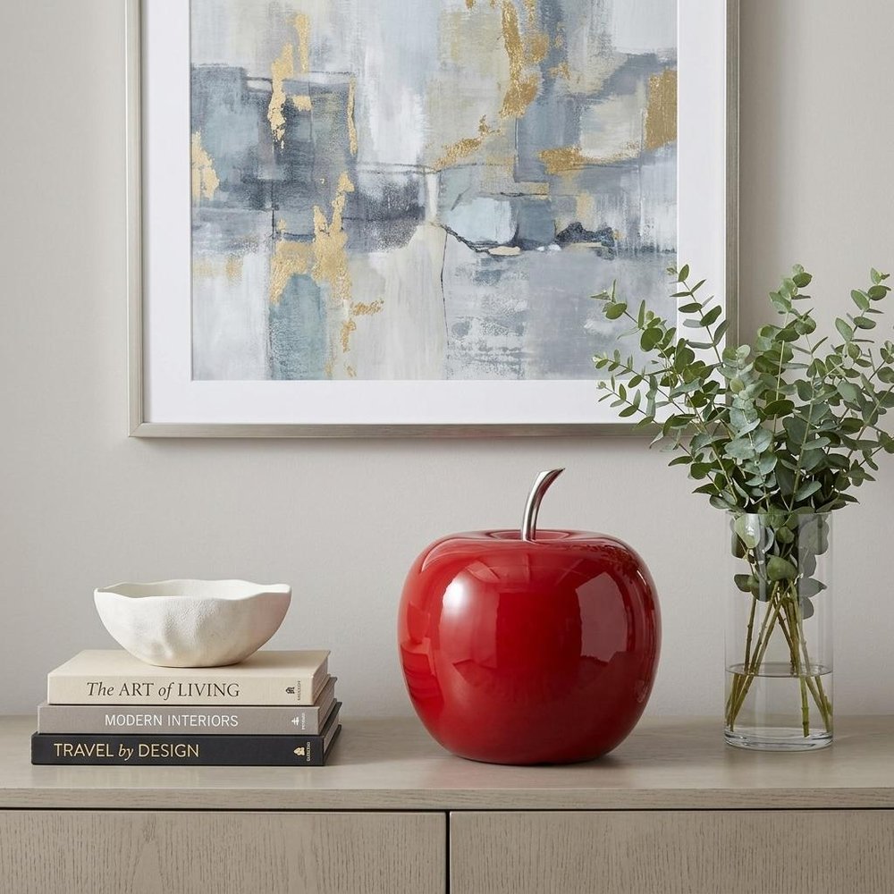 6" Red Aluminum Decorative Apple Tabletop Sculpture displayed on a wood tabletop in a furnished interior against a light gray wall in silver metal.