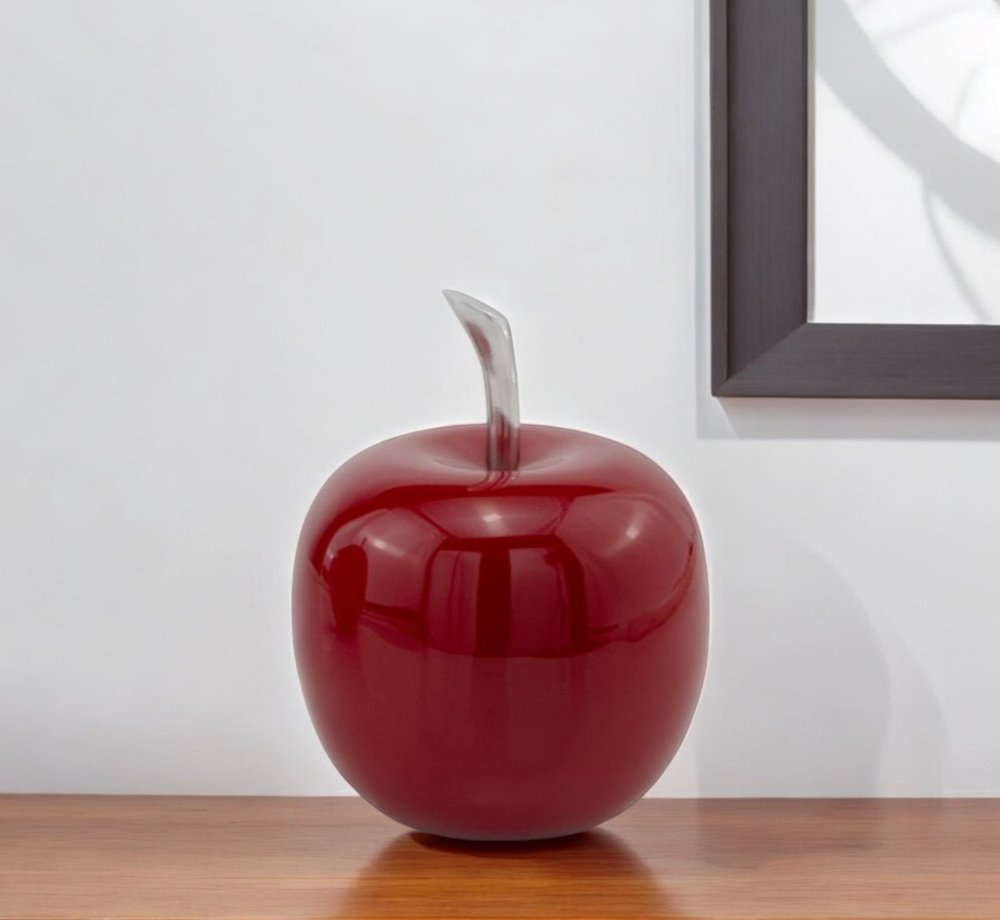 6" Red Aluminum Decorative Apple Tabletop Sculpture displayed on a wood tabletop in a furnished interior against an off-white wall in silver metal.
