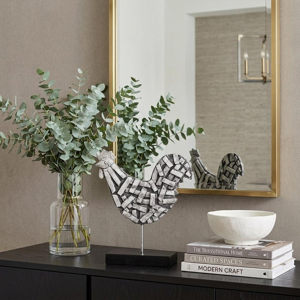 11" Black and Silver Aluminum Tabletop Sculpture styled in a furnished interior with a tan wall on a black floor.