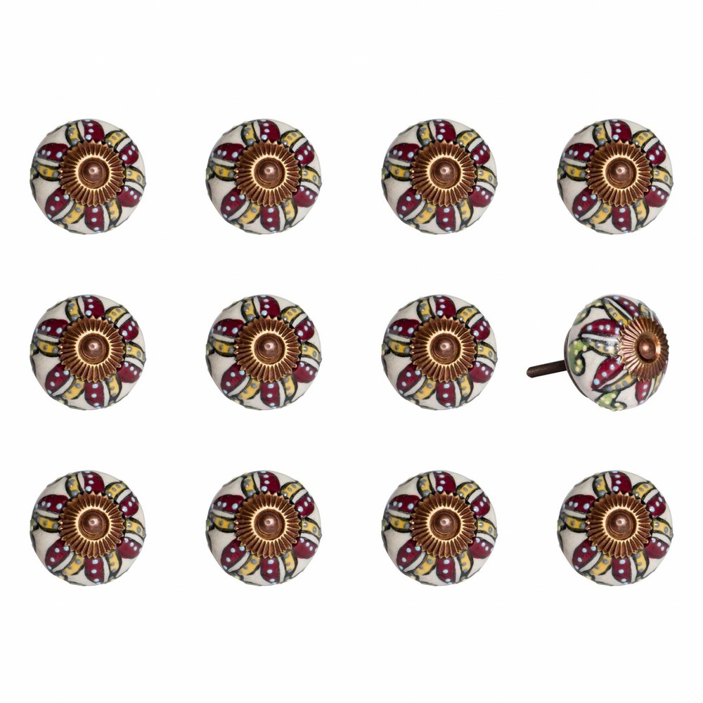 Twelve round ceramic drawer knobs with a red, yellow, and white botanical pattern and a brass center on a white background.