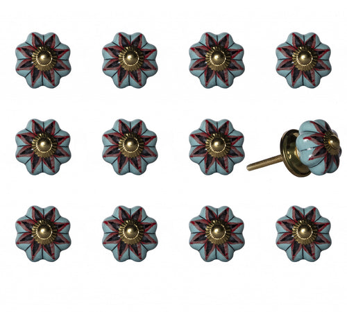 Twelve light blue ceramic drawer knobs with red and black floral design and gold center, one knob with visible screw, on white background.