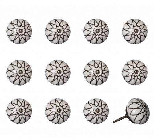 Twelve white ceramic drawer knobs with black starburst pattern and metal screws on a white background.