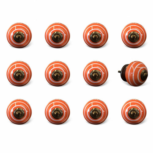 Twelve orange ceramic cabinet knobs with white stripes and a brass center, displayed on a white background.