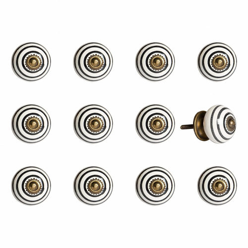 Twelve round ceramic drawer knobs with black and white stripes and a gold center, on a white background.