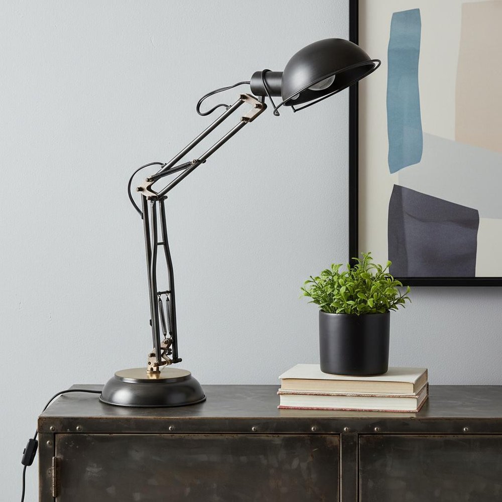 33" Black Metal Desk Table Lamp With Black Bowl Shade displayed on a tabletop in a furnished interior against an off-white wall.