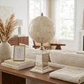 15" Bone Metal Hand Painted Figurine Tabletop Sculpture styled in a furnished interior with an off-white wall on a dark wood floor in tan metal.
