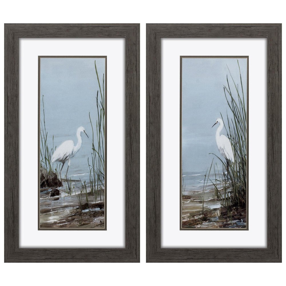 Two framed paintings of white egrets standing in tall grass by the water, with dark brown frames.