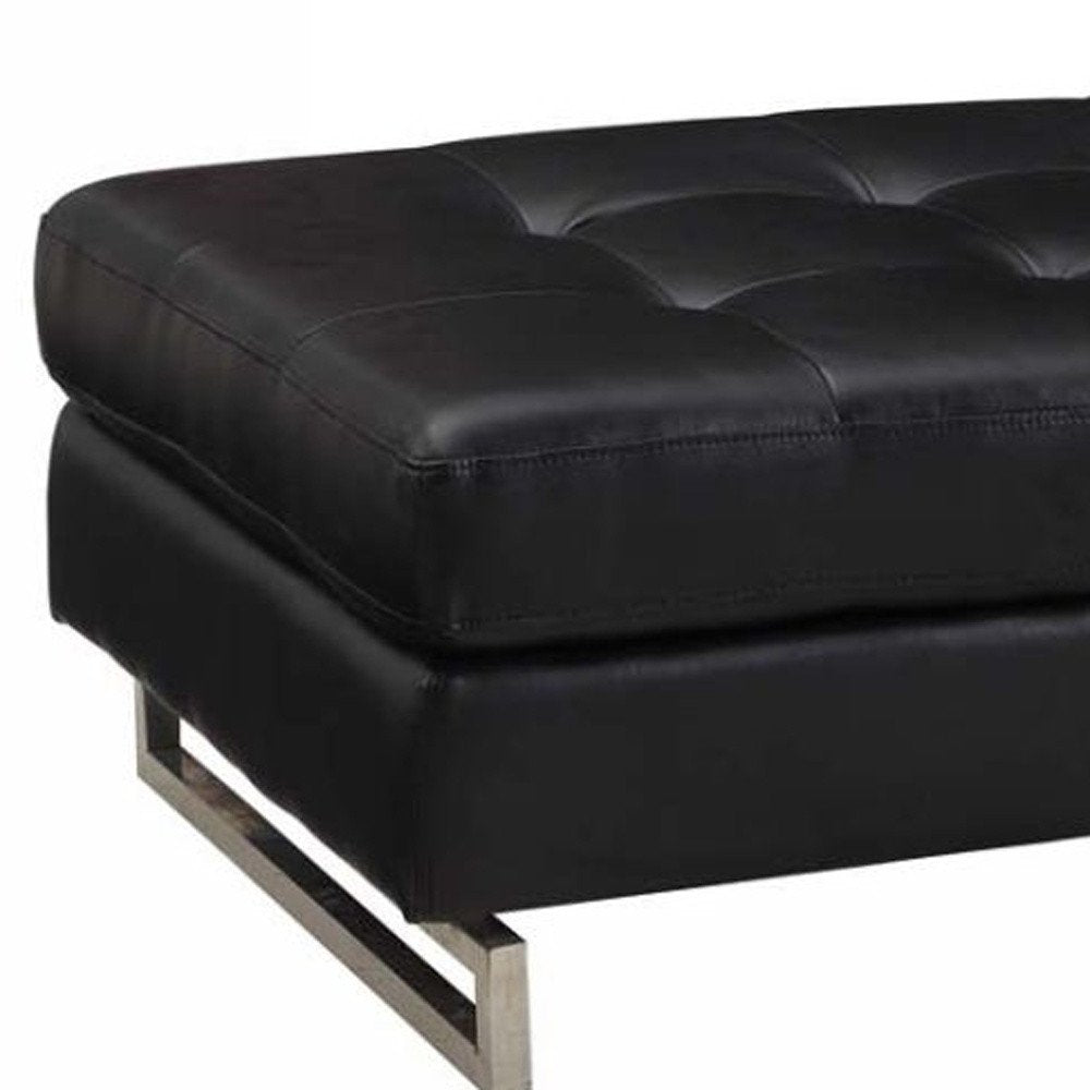 63" Black Tufted Faux Leather and Silver Ottoman. Ottoman isolated on a plain white background, showing a silver faux leather surface.