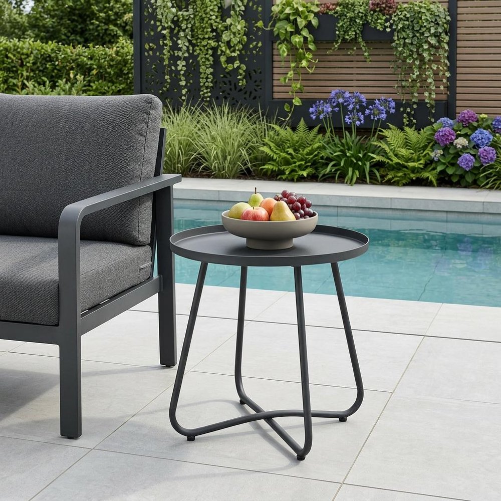 18" Gray Rounded Aluminum Outdoor Side Table shown outdoors on a patio with greenery.