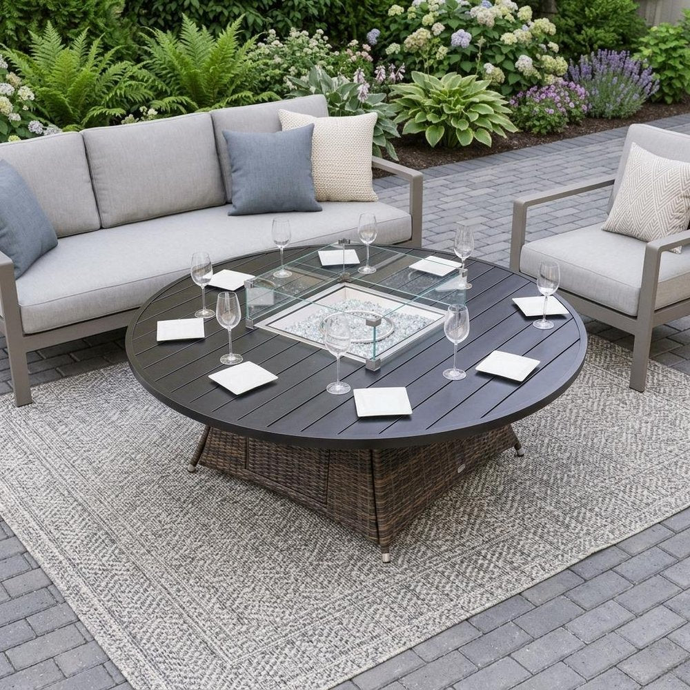 50000 BTU 325" Brown Aluminum Propane Round Fire Pit shown outdoors on a tiled patio with greenery.
