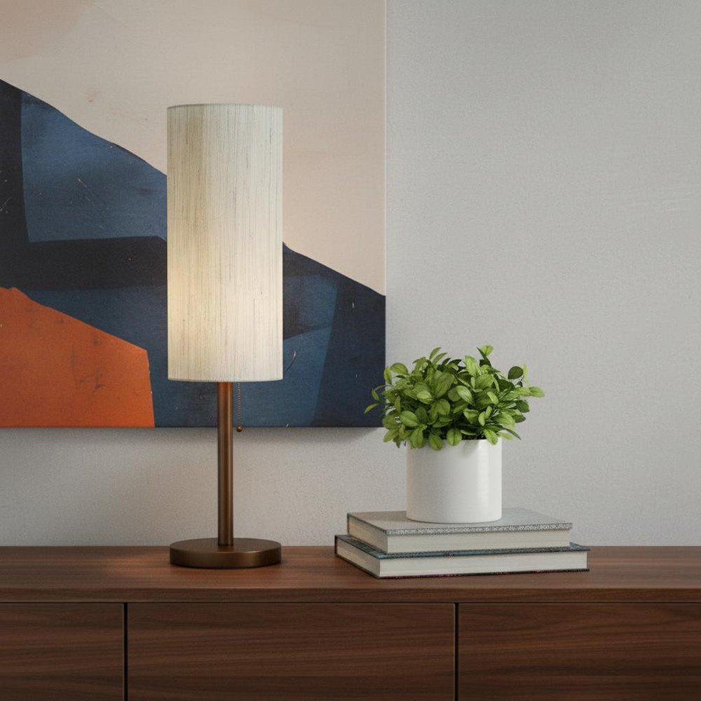 31" Walnut Solid Wood Standard Table Lamp With Beige Shade displayed on a dark wood tabletop in a furnished interior against a tan wall.