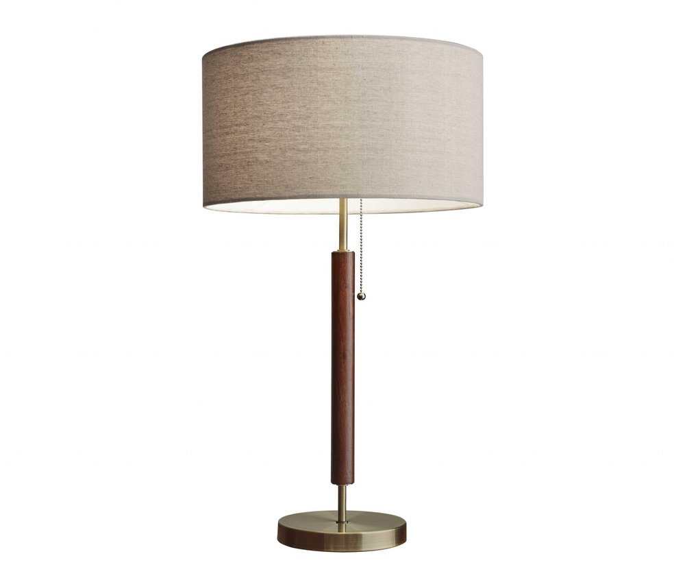 26" Antiqued Brass Solid Wood Table Lamp With Beige Drum Shade. Table lamp isolated on a plain white background, in a beige wood finish.