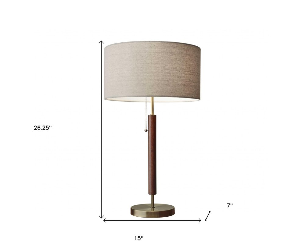 26" Antiqued Brass Solid Wood Table Lamp With Beige Drum Shade. Table lamp isolated on a plain white background, in a beige wood finish.