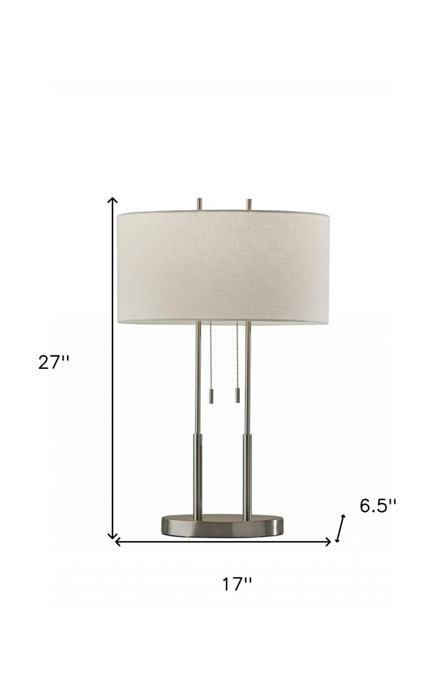 27" Silver Metal Two Light Bedside Lamp With Off White Drum Shade. Lamp isolated on a plain white background, in a off-white metal finish.
