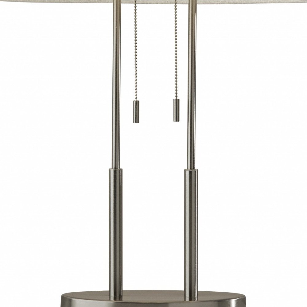 27" Silver Metal Two Light Bedside Lamp With Off White Drum Shade. Lamp isolated on a plain white background, in a off-white metal finish.