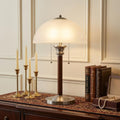 23" Silver Metal Standard Table Lamp With White Shade displayed on a dark wood tabletop in a furnished interior against a cream wall.