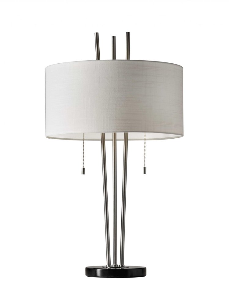 A brushed steel table lamp with a white drum shade and three metal poles on a black base, isolated on a white background.