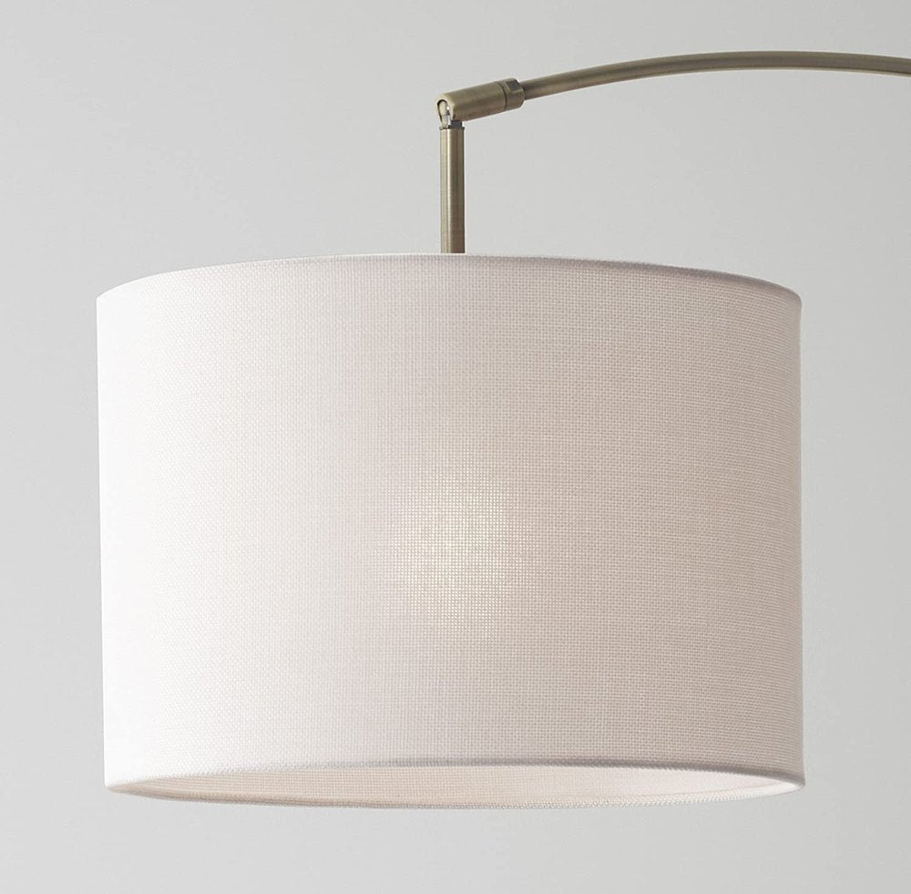 74" Brass Metal Arc Floor Lamp With Off White Linen Drum Shade on a white background