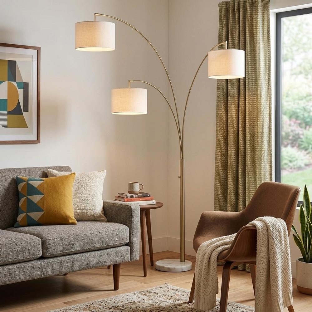 74" Brass Three Light Arc Floor Lamp With Off White Fabric Drum Shade in a home interior