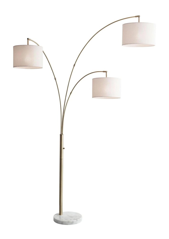 74" Brass Three Light Arc Floor Lamp With Off White Fabric Drum Shade on a white background