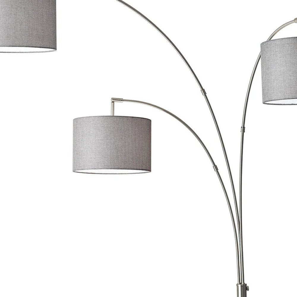 74" Brass Three Light Arc Floor Lamp With Off White Fabric Drum Shade on a white background