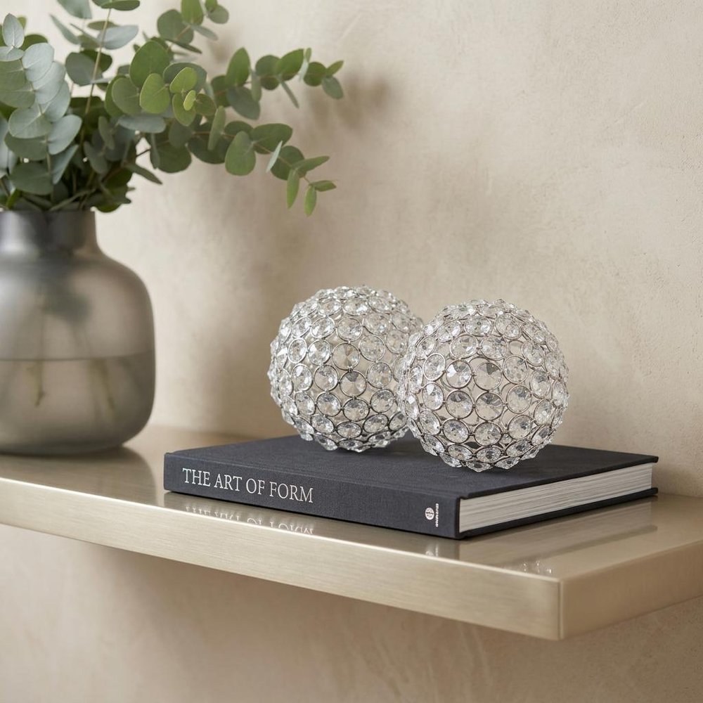 Set of Two Clear And Silver Faux Crystal And Steel Decorative Orb Tabletop Sculptures in a home interior