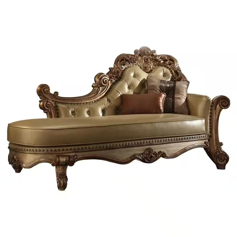 Ornate bone and pearl faux leather tufted chaise lounge with carved wood frame and toss pillows on a white background.