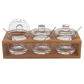 6 Mouth Blown Crystal Jam Set With 3 Glass Jars And Spoons On A Wood Stand. Kitchen accessory isolated on a plain white background, showing a glass surface.