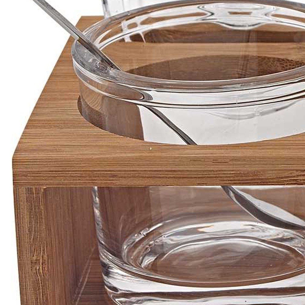 Cropped view of 6 Mouth Blown Crystal Jam Set With 3 Glass Jars And Spoons On A Wood Stand focusing on the glass surface.