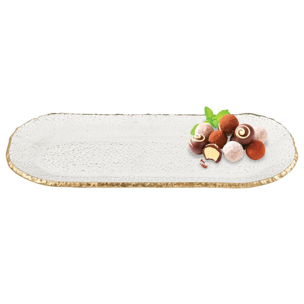 Oval glass platter with textured surface and gold leaf edge, holding a pile of assorted chocolates and mint leaves on a white background.