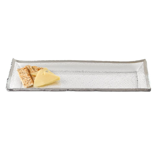 Rectangular clear glass serving tray with textured surface and silver rim, holding crackers and cheese on a white background.