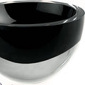 Close-up of a black and clear mouth-blown crystal bowl with a thick wall on a white background.